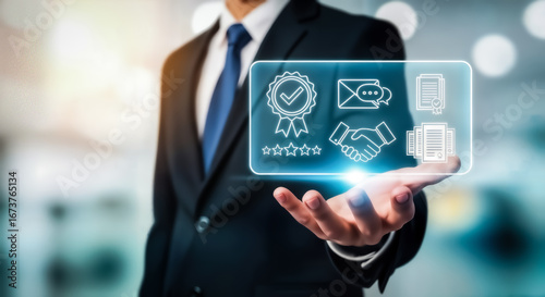 Wallpaper Mural Businessman holding a holographic interface displaying icons for quality assurance, customer service, and business partnership, representing excellent service and customer satisfaction Torontodigital.ca