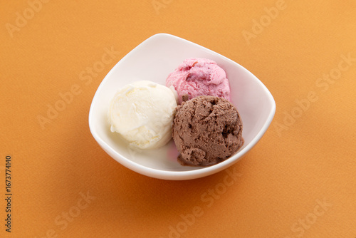 Three scoops of ice cream in a bowl.