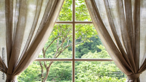 Linen curtains frame a tranquil view of vibrant greenery beyond the window panes