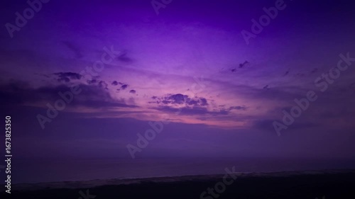 Luftaufnahme eines lilafarbenen Himmels kurz nach Sonnenuntergang an der französischen Atlantikküste, Drohne von harmonischen Wolken