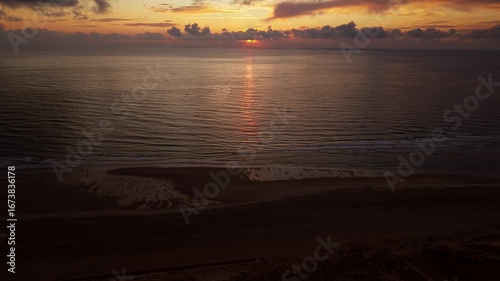 Luftaufnahme eines Sonnenuntergangs mit Drohne an der Atlantikküste in Frankreich, Ozean im Hintergrund, dramatische Wolken