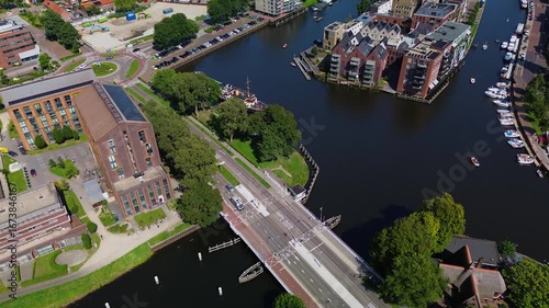 Utrecht, Utrecht region, Netherlands - 09.06.2025: Aerial view of a modern cityscape with a river, industrial buildings, boats, and residential areas. A busy road with a bridge crosses the water
