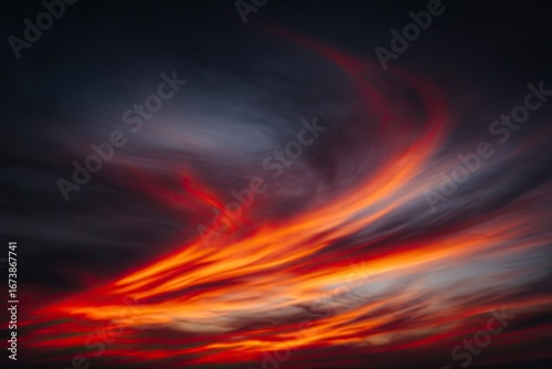 Fiery sunset clouds blaze across a dark sky