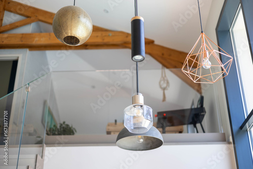 Plusieurs luminaires tous différents accrochés sur le plafond d'une villa moderne