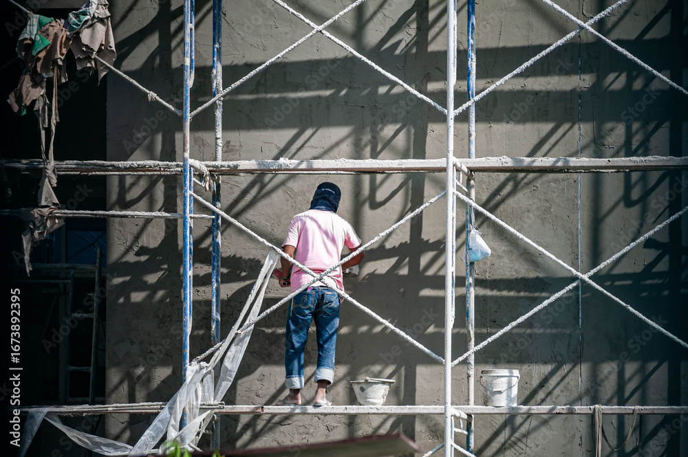 Fototapeta premium Worker on Scaffold for Building Renovation