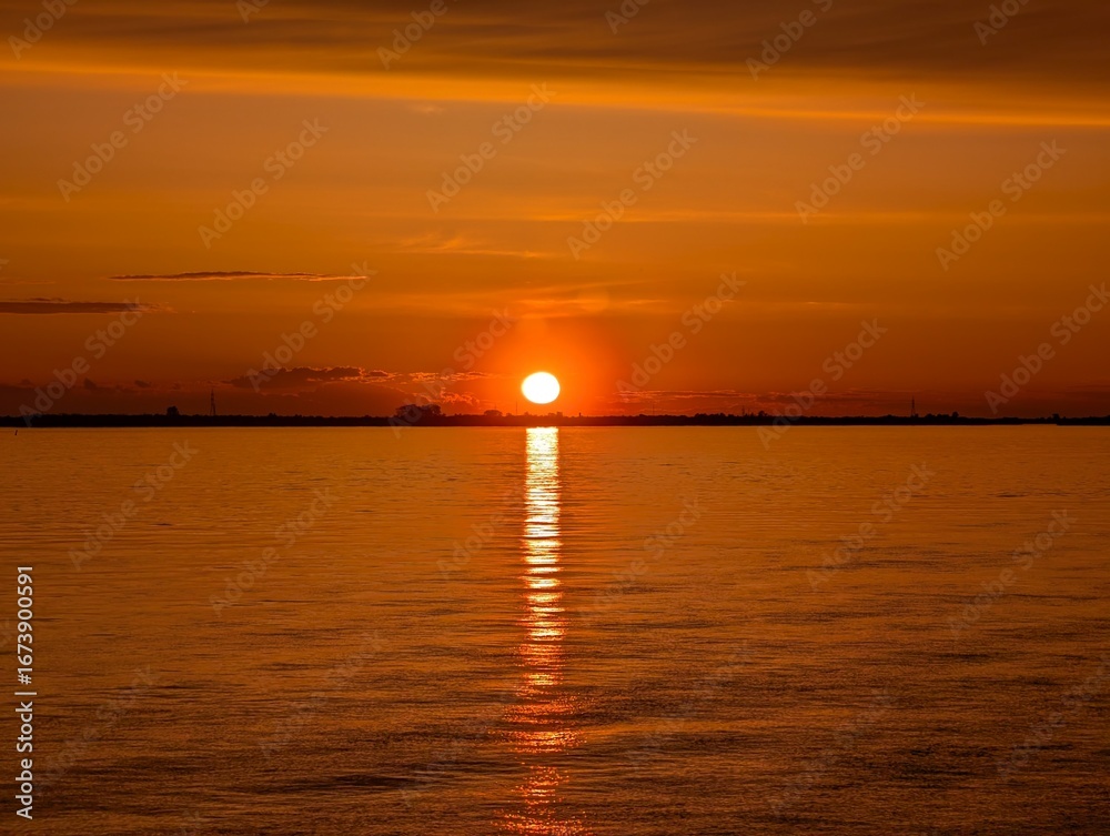 Fototapeta premium A Stunningly Beautiful Sunset Over a Peaceful Water Reflection Scene