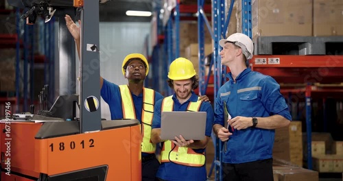 three warehouse professionals including african american staff and caucasian supervisors collaborating beside forklift using laptop during shipment task inside organized distribution facility