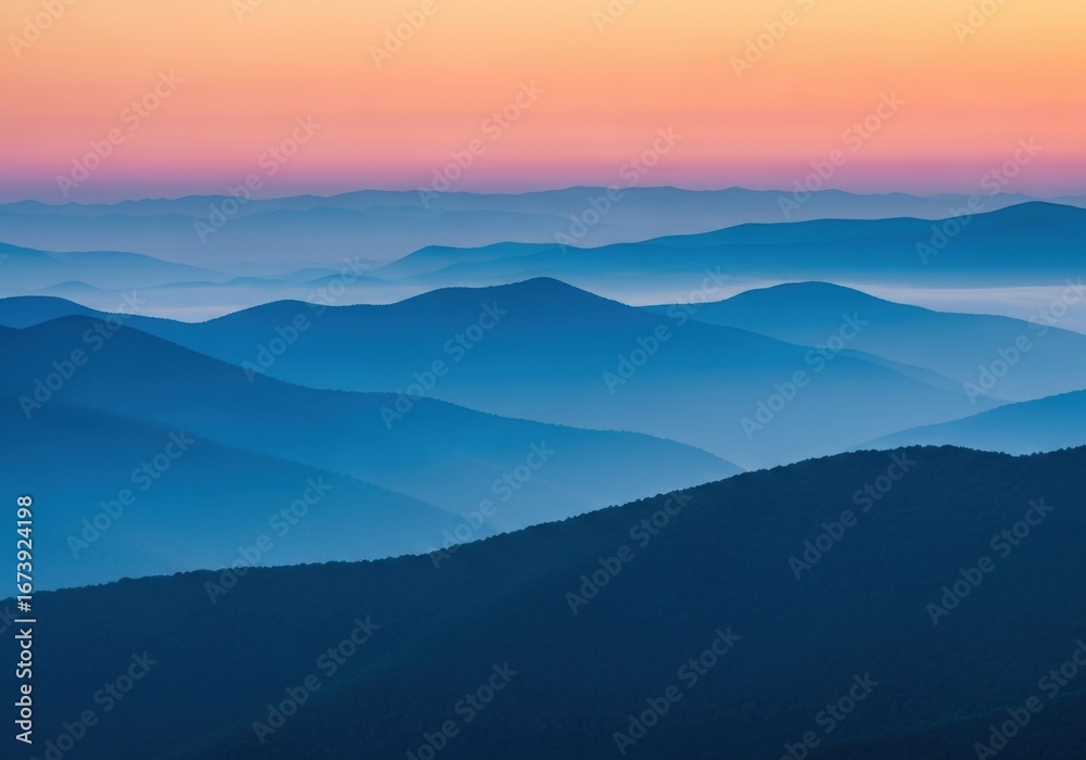 Obraz premium Serene mountain range landscape with misty atmosphere at colorful dawn