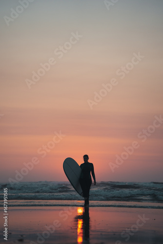 Surfing woman with a surfboard on a beach