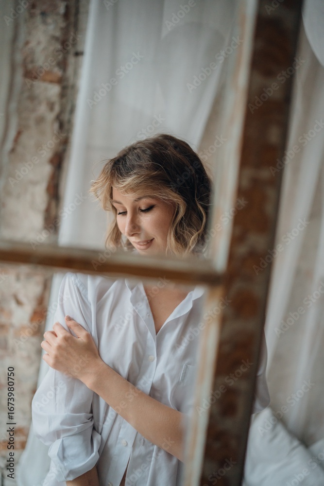 Fototapeta premium sexy woman in white shirt through the window frame.