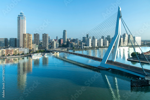 Maas River with Erasmus Bridge in Rotterdam, the Netherlands high rise buildings Zalmhaventoren with reflection of buildings and bridge in tranquil waters of river
