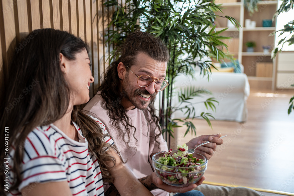 Obraz premium Happy couple enjoying healthy salad at home