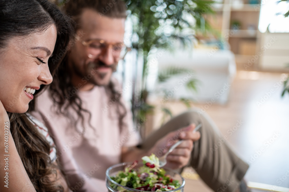 Fototapeta premium Happy couple enjoying fresh salad at home