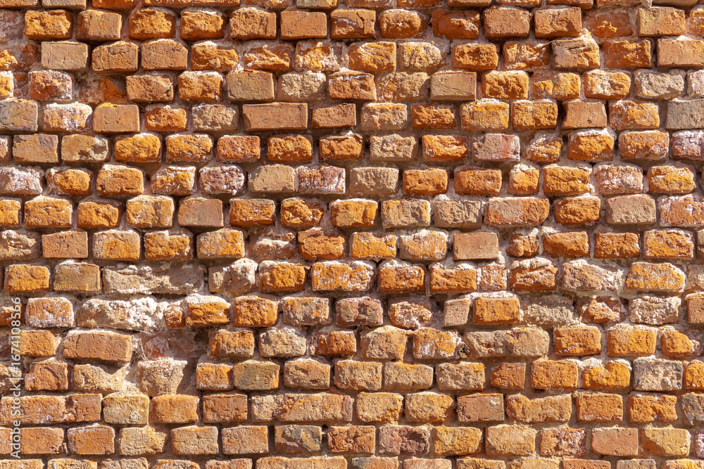 Obraz premium Brick wall in natural red and brown tones, featuring signs of aging and uneven texture. Visible joints and wear add a vintage feel to the surface.