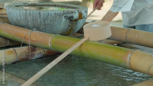 手水舎で手を清める人。水面に水の落ちる音