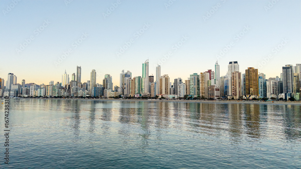 Fototapeta premium Balneario Camboriu skyline with skyscrapers reflecting on the sea at sunset, Santa Catarina, Brazil.