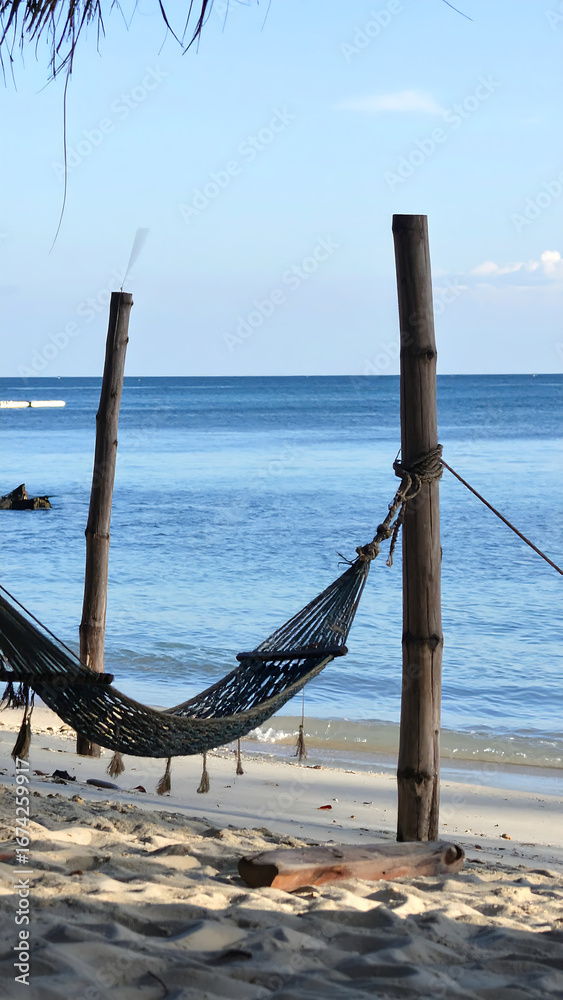 Obraz premium Empty hammock on sandy beach by ocean