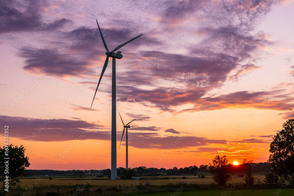 Obraz premium Swedish wind energy turbines glowing in summer sunset light
