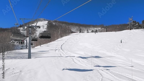 Riding a bubble quad lift at sunny ski resort (Madarao, Nagano, Japan)