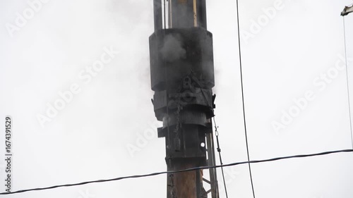 Close-up view of pile driver hammering concrete pile at a construction site. Overcast sky. Real time video. Deep foundation theme.