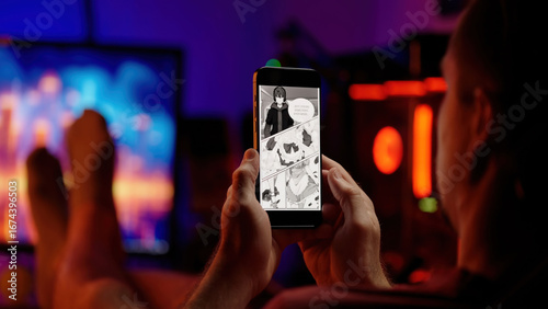 Person reading cute maid girls black and white manga comic on smartphone over shoulder view