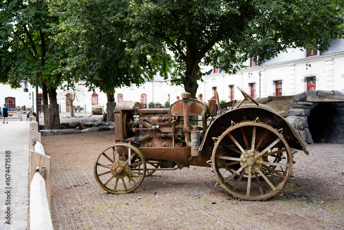 A broken old tractor stands on a farm