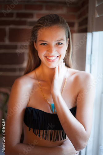 Head shot of beautiful girl hand on neck wearing turquoise necklace