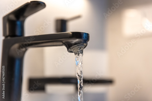 Black tap macro. Water flow. Minimal aesthetic