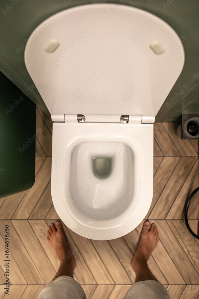 Fototapeta premium Person over toilet. Modern bathroom design. Top view