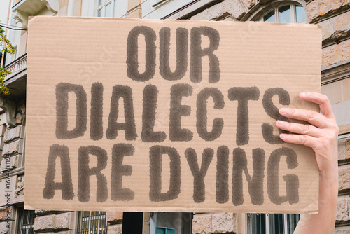 Bild auf Leinwand "Our dialects are dying" on a protest banner highlighting threats to linguistic heritage