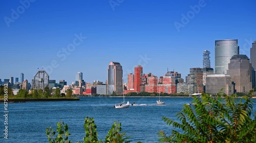 Boats and jet ski scooters on the blue waterscape of the Hudson River. View from the waterfront of Jersey, NJ, USA. Manhattan at backdrop.
