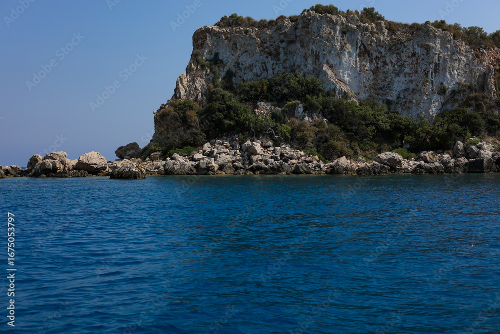 Fototapeta premium Scenic rocky island in the mediterranean sea on sunny day and blue sky. Turquoise water and bright summer atmosphere