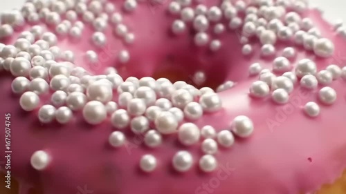 Pink glazed donut with white pearl sprinkles