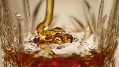 Amber liquid pouring into ornate glass