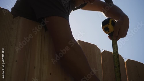 Worker Measuring Cedar Fence Pickets with String Line in Slow Motion