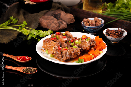 Foto Spicy braised oxtail stew with fresh vegetables and herbs on white plate - tradi