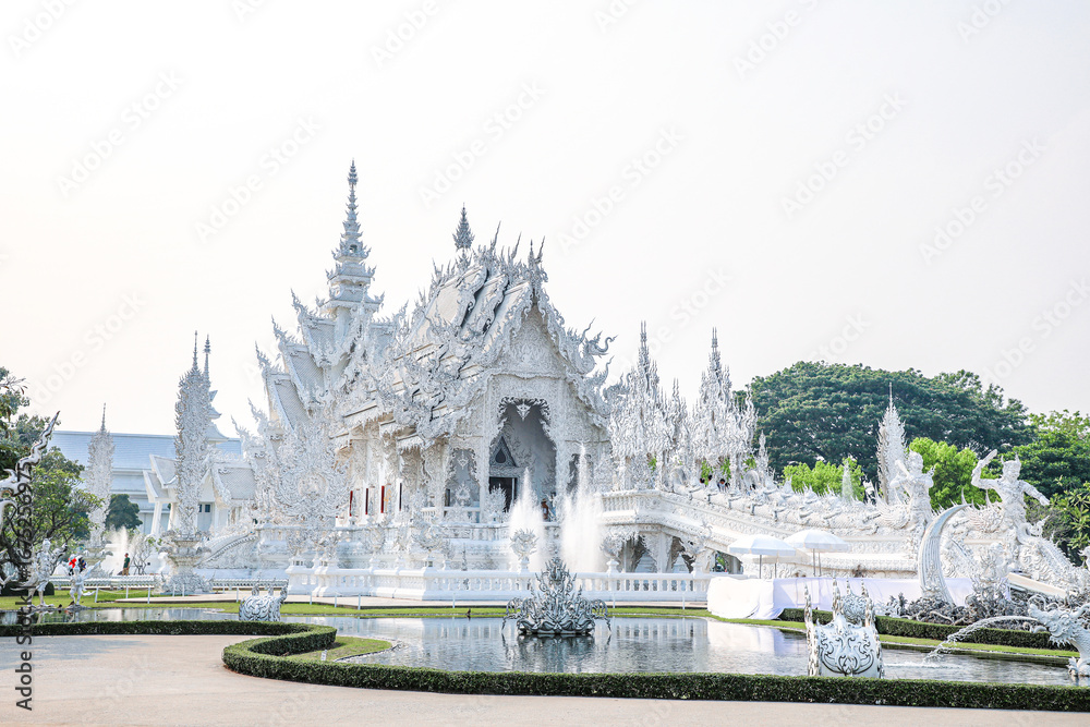 Fototapeta premium Wat Rong Khun, or the White Temple, is a Buddhist temple located in Chiang Rai, Thailand. The temple attracts many tourists. The White Temple was built by Chalermchai Kositpipat, who also designed