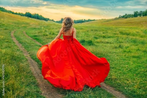 happy fantasy blonde hair woman queen running walking in green field summer nature sunset blue sky, long red dress fluttering skirt silk fabric waving fly slow motion joy girl princess back rear view