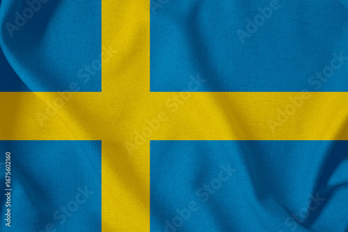 blue flag of the Kingdom of Sweden with a yellow Scandinavian cross on a rough canvas with folds