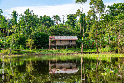 Einfache traditionelle Holzhütte an einem Flussufer im Amazonas-Regenwald