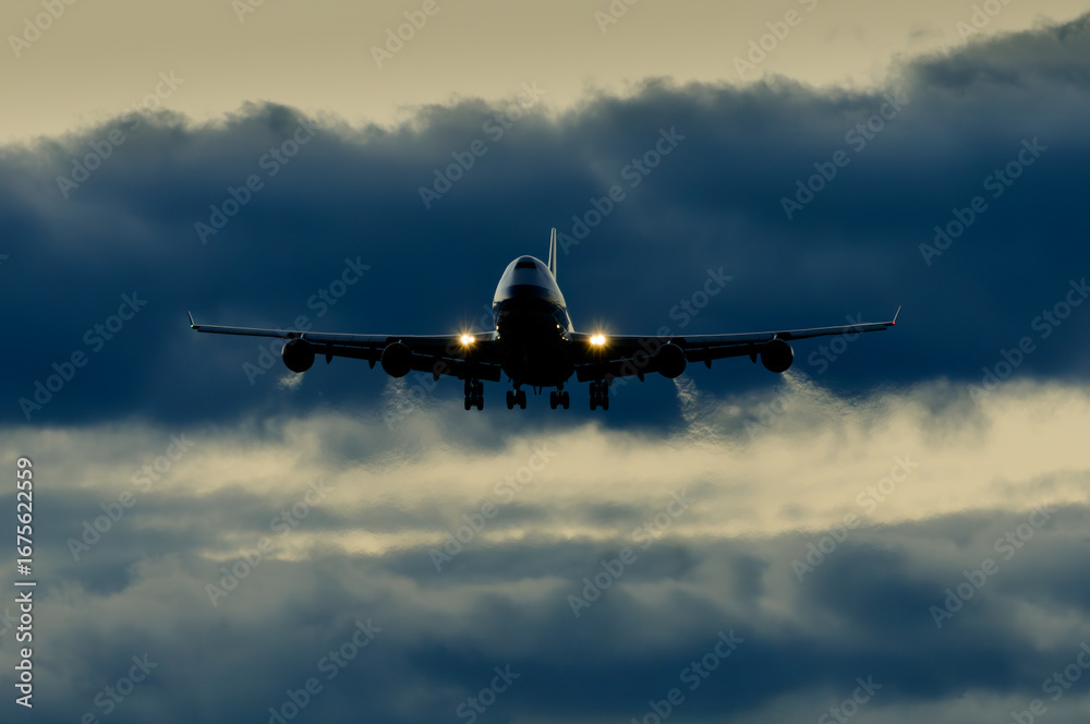 Fototapeta premium 美しい太陽・光・雲・空を背景に飛ぶ航空機