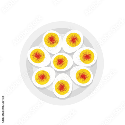 A plate of sliced hard-boiled eggs, artfully arranged, showcases vibrant yellow yolks and a sprinkle of red seasoning.