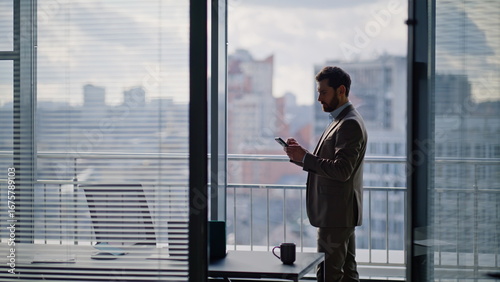 Cuadro en lienzo Elegant business owner messaging smartphone panoramic window