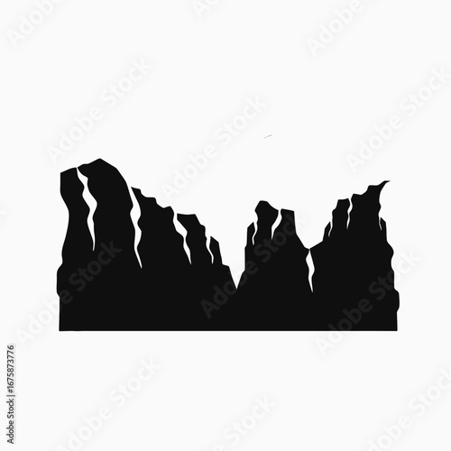Imposing mountain range displays the majestic rugged rock formations in stark silhouette