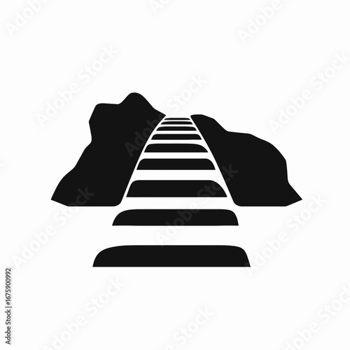 Railroad track crossing through rocky mountains creating a striking graphic silhouette