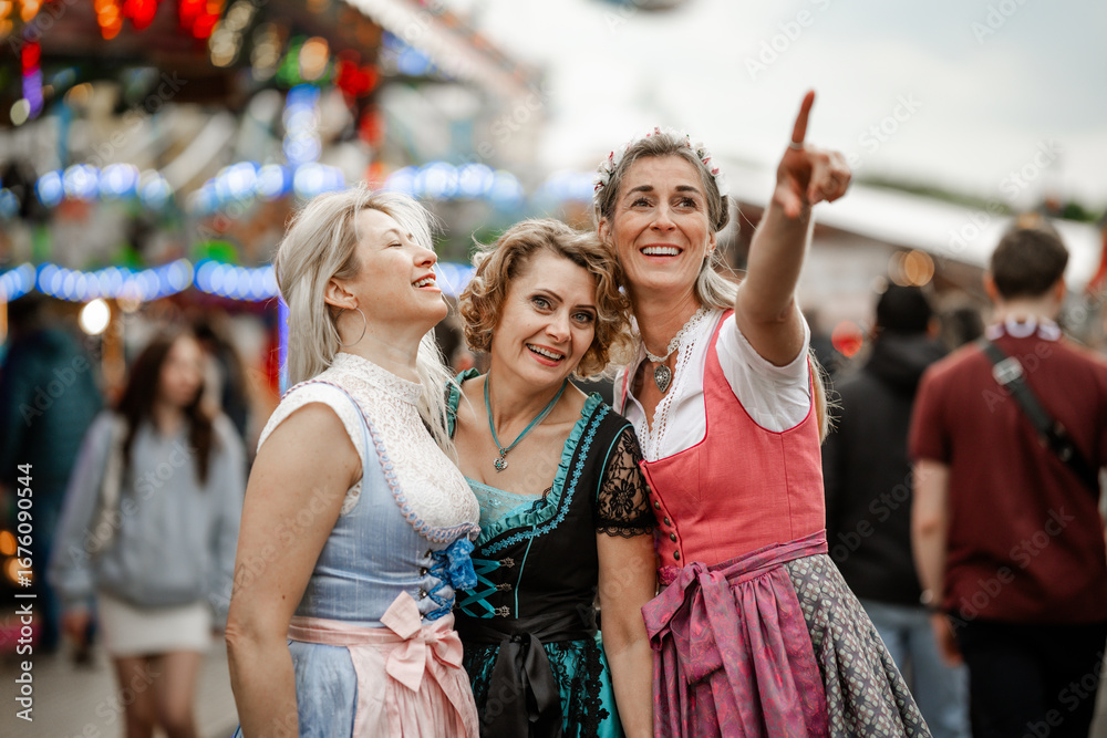 Fototapeta premium Three women dressed in colorful Bavarian costumes enjoy folk festivals like Munich Oktoberfest Gäubodenvolksfest in Straubing and Regensburg Dultfest Germany