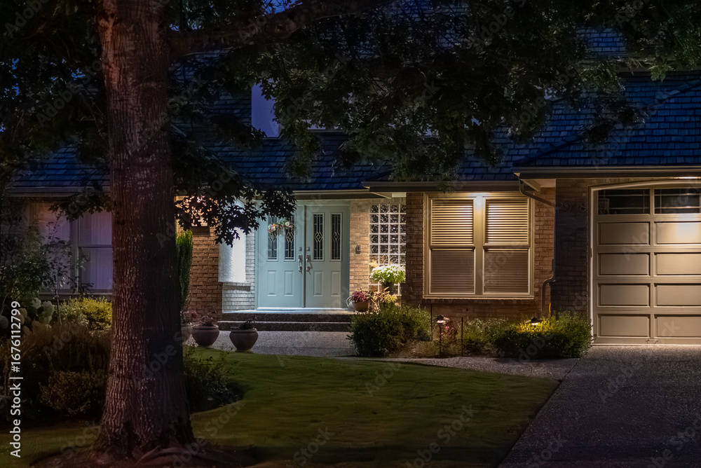 Obraz premium Two story stucco luxury house with big tree and nice landscape at night at Summer in Vancouver, Canada, North America. July 2025.