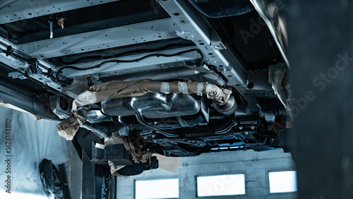 Automotive technician applying rustproof protective coating under a vehicle. Process helps prevent corrosion and extend vehicle lifespan. Ideal for illustrating car maintenance, vehicle care.