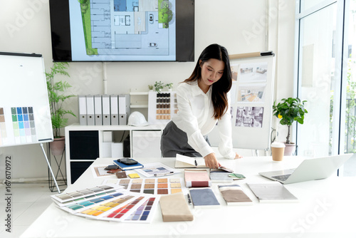 Architect professional reviews sustainable building blueprint selecting eco friendly materials for green construction project development modern office studio.