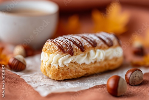 Mini eclair with vanilla cream and caramel drizzle on parchment, autumn cozy food styling